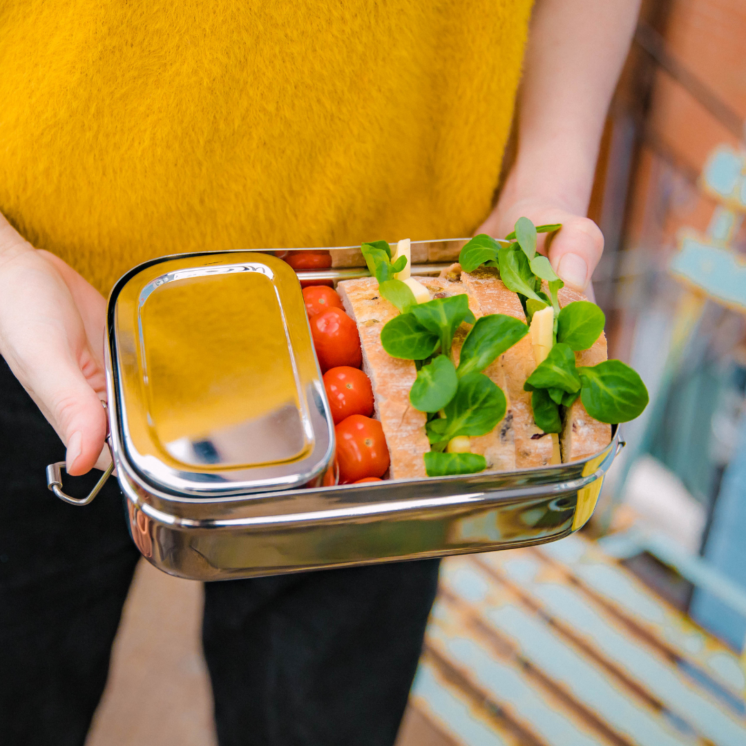  Stainless steel lunch box with snack pod dividing main compartment of the lunch box.