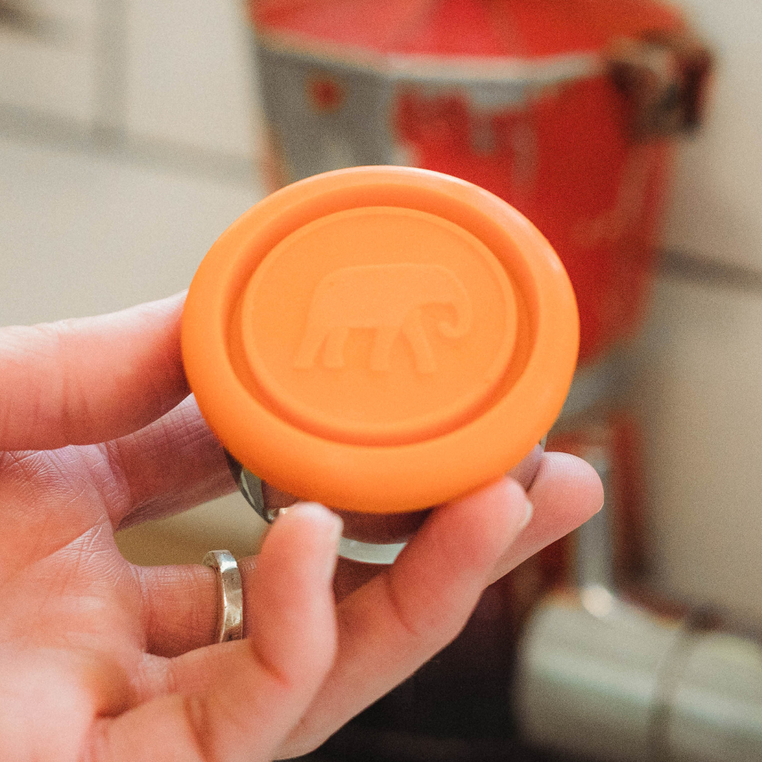 replacement orange silicone dressing pot lid on a white background