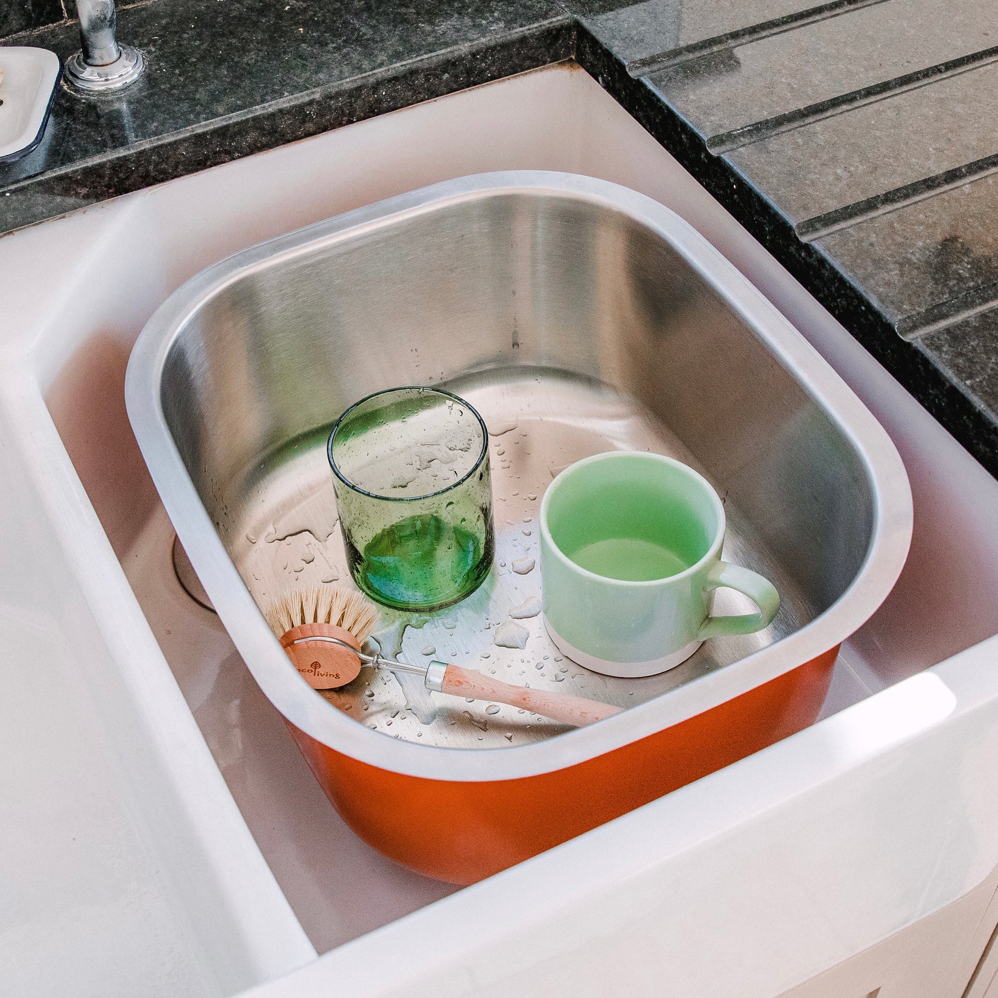A large 10 litre stainless steel washing up bowl with a vibrant orange powder coat finish. 