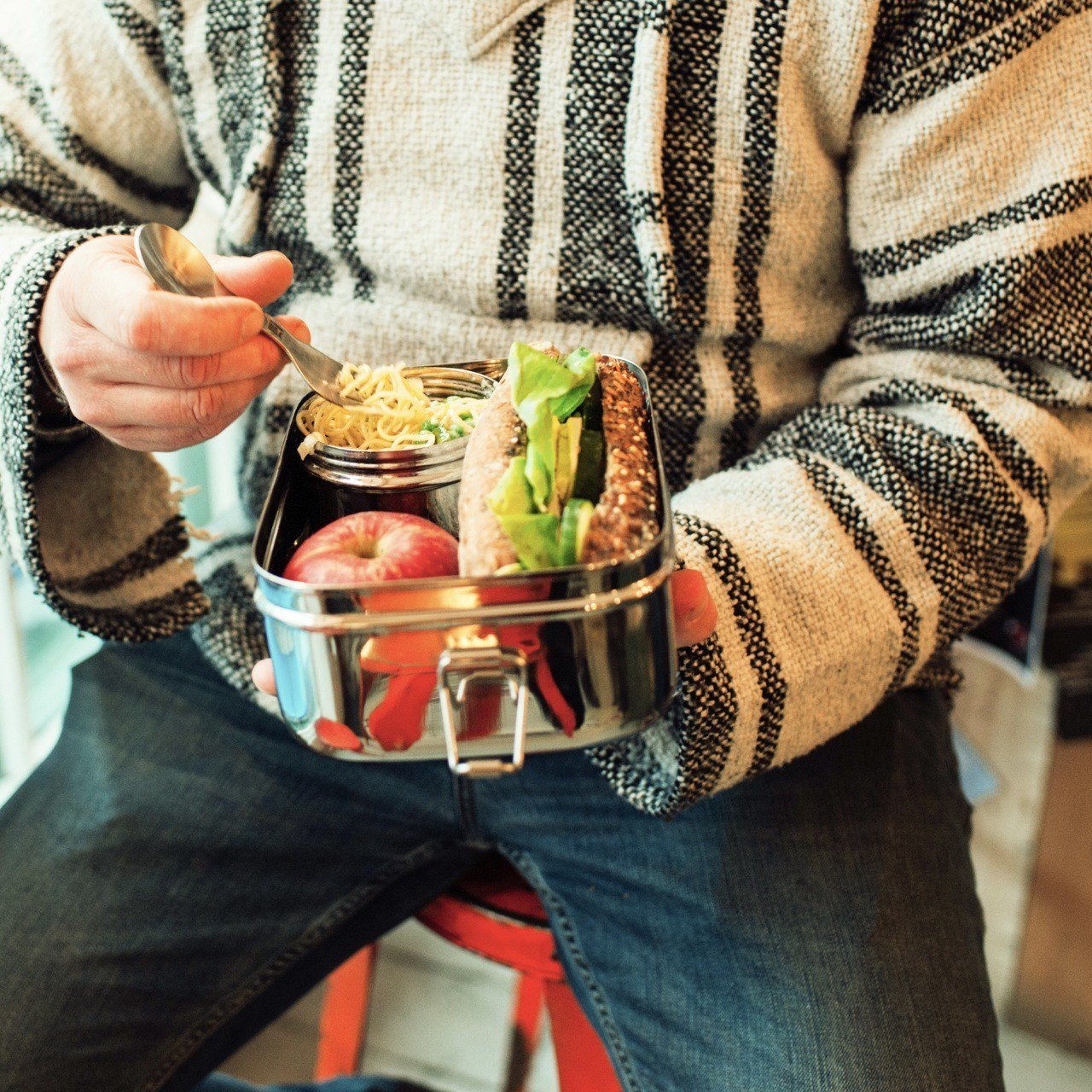 Man eating lunch out of large metal lunchbox using a spork Elephant Box